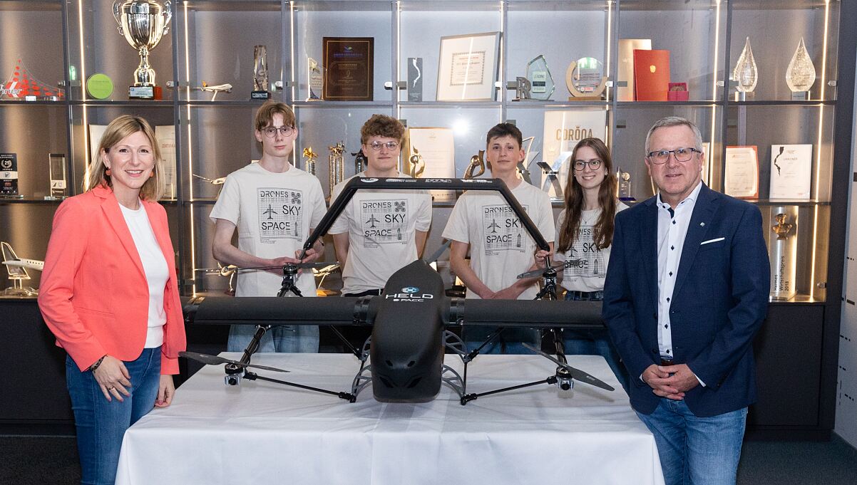 FACC CEO Robert Machtlinger und VP HR Martina Hamedinger mit den Schüler*innen des HELD Projekts und der gemeinsam entwickelten Drohne.
